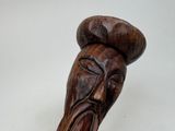 a wooden sculpture of a man with a hat on his head