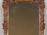 an antique wooden mirror on a shelf with a white wall in the background