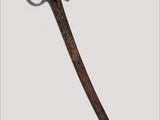 a close up of a sword on a white surface