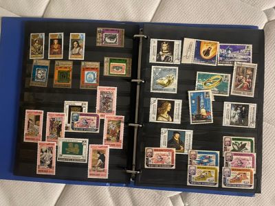 un classeur bleu orné de timbres, posé sur un lit