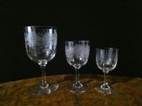 three wine glasses sitting on top of a table next to each other