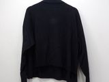 black turtle neck sweater on a hanger against a white wall
