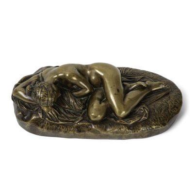 statue en bronze représentant une femme allongée sur un rocher avec un lion