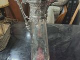 une cafetière en argent posée sur une table, sur laquelle est posée une note