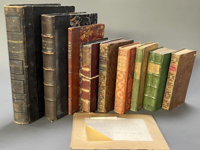 several old books are stacked on top of each other on a table