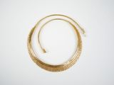 a close up of a gold necklace on a white surface
