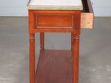 an old wooden table with a marble top and a drawer