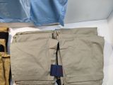 several pairs of men ' s pants are laid out on a white surface