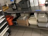 une cuisine équipée d'une table en inox et de nombreux récipients