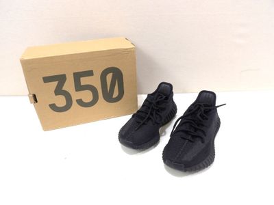 a pair of black sneakers sitting next to a cardboard box