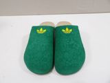 a pair of green slippers sitting on top of a white table