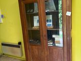 un meuble en bois avec une porte en verre dans le coin d'une pièce