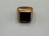 a gold ring with a black stone in the center