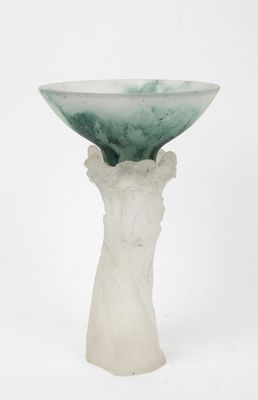 une image représentant un vase blanc surmonté d'un bol en verre vert