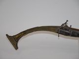 a close up of a brass plated gun on a clear stand