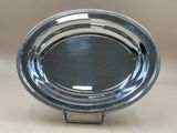 a close up of a silver plate on a white surface