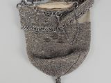 un vieux sac à main accroché au mur, entouré d'une chaîne