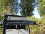 a grill on a cart in the middle of a field