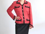 une femme vêtue d'une veste rouge et d'une jupe noire qui pose pour une photo