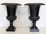 two black vases sitting on a white table
