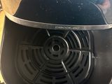 a person that is putting something in the air fryer