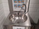 a stainless steel sink with a sign on it