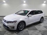Une Volkswagen Passat blanche est garée dans une grande pièce.