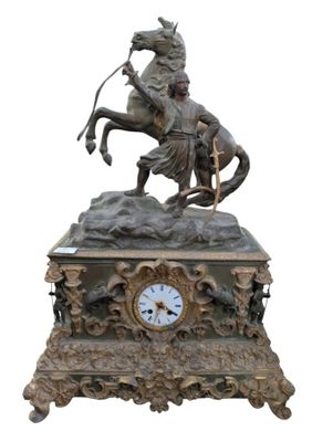 une statue en bronze représentant un homme à cheval, avec une horloge