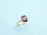 an image of a gold ring with a red stone on it