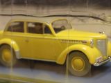 a yellow toy car in a glass case on display