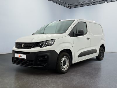 La camionnette blanche est garée dans une grande pièce.