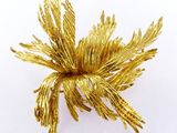 une image représentant une broche en forme de fleur dorée sur fond blanc