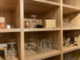 many glasses and bottles on the shelves in the room