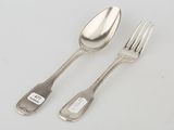 two forks and a spoon on a table with a tag on it