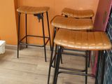 three stools in the corner of a room with orange walls
