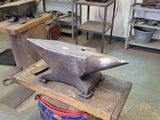 a metal anvil sitting on a table in a workshop