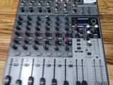 une console de mixage posée sur une table en bois