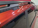 a close up of a red car with a clock on it ' s roof