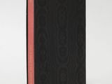 a black book with a red stripe on the cover