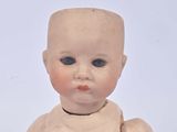 a small doll that is sitting on a white surface