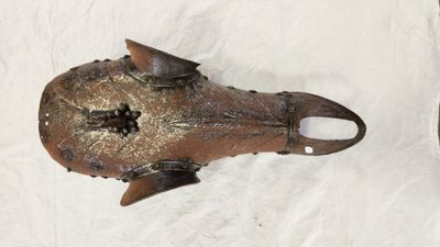 un objet métallique qui ressemble à un poisson posé sur un drap blanc