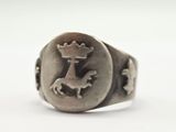 une image représentant une bague en argent ornée d'un cheval et d'une couronne