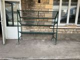 a green metal frame with a basket on top of it