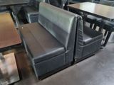 tables and chairs in a restaurant with a black leather couch