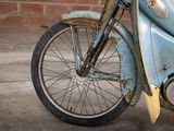 an old blue motorcycle parked on the side of the street
