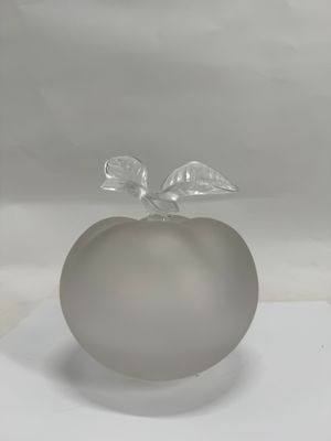 a glass apple with a leaf on top of it