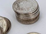 several silver coins sitting on top of each other on a white surface