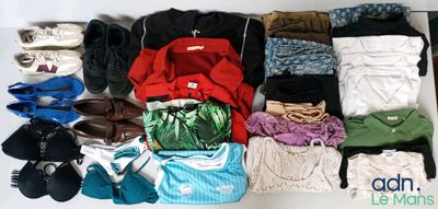 de nombreuses paires de chaussures et de vêtements disposés sur une table