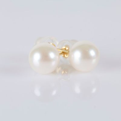 a pair of pearl earrings on a white surface