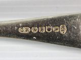 a silver spoon with a name on it on a white surface